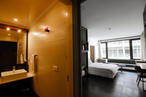 a bathroom with a bed and a sink in a room at Hamra Urban Gardens in Beirut