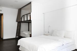 a bedroom with a white bed and a bunk bed at Hamra Urban Gardens in Beirut