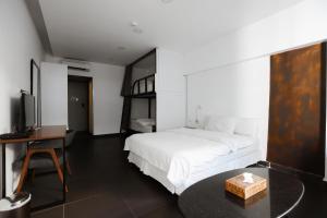 1 dormitorio con cama, mesa y TV en Hamra Urban Gardens en Beirut