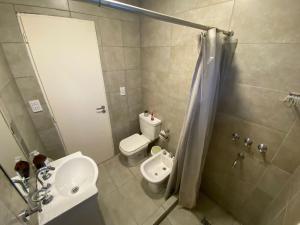 uma casa de banho com um lavatório, um WC e um chuveiro em Departamento con gran balcón a la calle y parrilla em Corrientes