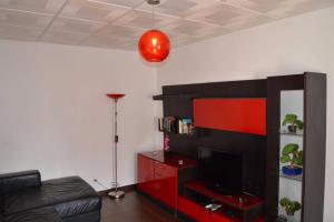 una sala de estar con TV y un centro de entretenimiento rojo en Casa Rosa en Monte Gordo