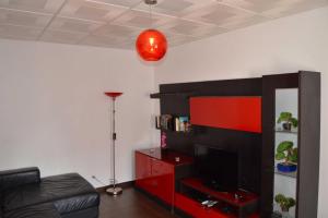 ein Wohnzimmer mit Fernseher und rotem Entertainment-Center in der Unterkunft Casa Rosa in Monte Gordo