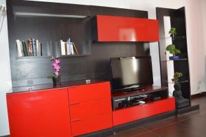 a red entertainment center with a television on it at Casa Rosa in Monte Gordo