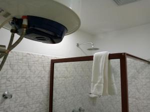 ナンプラにあるRESIDENCIAL AFRICA,LDA-NAMPULAのバスルーム(シャワー、タオル、照明付)