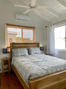 a bedroom with a bed and a ceiling fan at Sound of The Sea-walking distance to everything in Placencia Village
