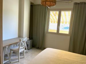 1 dormitorio con cama, escritorio y ventana en Casa Gaia, en Marina di Modica