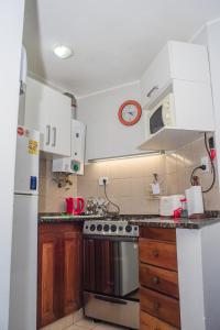 uma cozinha com armários de madeira e um frigorífico branco em Departamento increíble en Cordoba em Córdoba