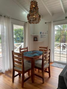 a dining room with a table and chairs and a chandelier at Sound of The Sea-walking distance to everything in Placencia