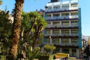 ein hohes Gebäude mit Palmen davor in der Unterkunft Hotel Oasis Plaza in Benidorm