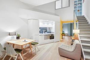 a living room with a table and chairs and a staircase at Ponsonby Delight with Wi-fi and Free Parking in Auckland