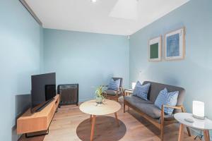 a living room with a couch and a tv at Ponsonby Delight with Wi-fi and Free Parking in Auckland