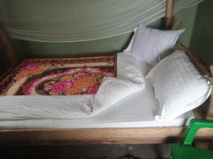 a bed with two pillows and a blanket on it at Lake Lyantonde eco campsite original in Fort Portal