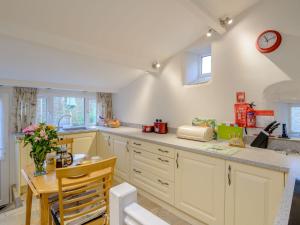 a kitchen with a table and a clock on the wall at Middle Cottage in West Burton