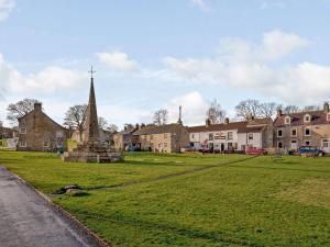 a village with a church and a grass field at Middle Cottage in West Burton