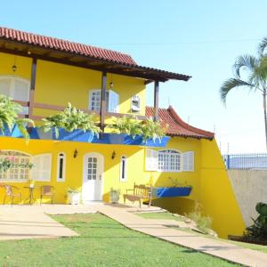 uma casa amarela com um telhado vermelho em La Maison Brasiliana B&B em Foz do Iguaçu