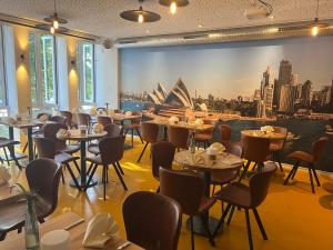 a restaurant with tables and chairs and a view of the opera house at Kangarooms - Schlachte Weserpromenade in Bremen