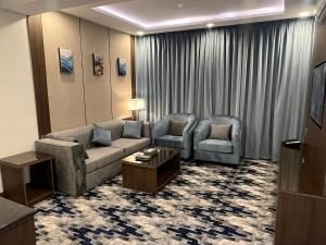 a living room with a couch and two chairs at Aman Hotel Suites in Abha