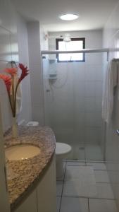 y baño con aseo, lavabo y ducha. en Apartamento Temporada Maceió, en Maceió