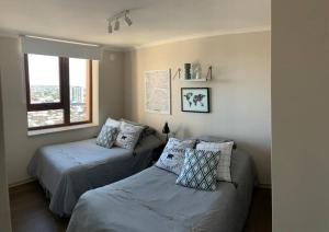 a bedroom with two beds and a window at Dpto vip excelente ubicación c/estacionamiento in Temuco