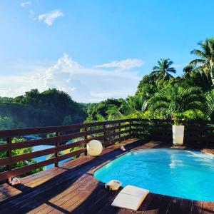 哥西尔Villa Mascotte proche Bas du Fort avec piscine的甲板上的游泳池,享有丛林美景