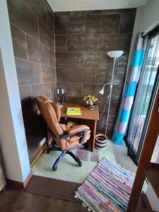 a desk with a chair and a lamp in a room at Het Boetje in Lagoa