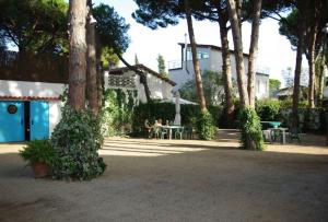 a group of people sitting at a table under trees at Enjoy your holidays 300m to the Mediterranean sea at Villa DIVALI in Castelldefels