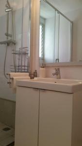 y baño con lavabo blanco y espejo. en Enjoy your holidays 300m to the Mediterranean sea at Villa DIVALI en Castelldefels