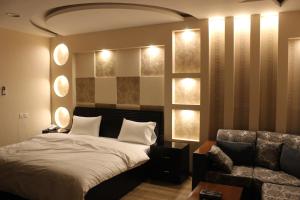 a bedroom with a bed and a couch and lights at شقق ليالي الشرق للوحدات 2 in Al Mubarraz +28 photos