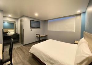 a bedroom with a bed and a bathroom with a sink at Hotel Estrella de Oriente in Mexico City