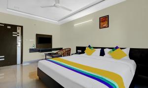 a bedroom with a large bed with a rainbow blanket at Itsy By Treebo - MVP Check Inn in Visakhapatnam