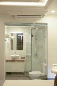 een badkamer met een douche, een wastafel en een toilet bij Mercy Hotel in Hanoi