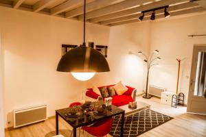 ein Wohnzimmer mit einem roten Sofa und einem Tisch in der Unterkunft Duplex entre centre ville et université in Pau