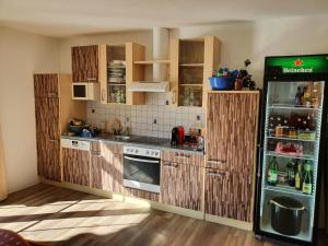 a kitchen with wooden cabinets and a refrigerator at Ferienwohnungen Forever in Gamlitz