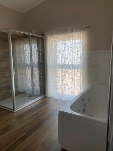 bagno con vasca e ampia finestra di Masseria Spinale Wine Resort a Melfi