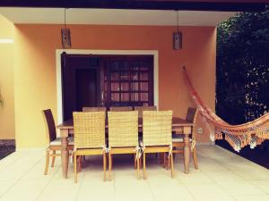 una mesa de madera y sillas frente a una casa en Casa 2 suítes com ar - Até 6 pessoas - em condomínio com piscina, en Lençóis