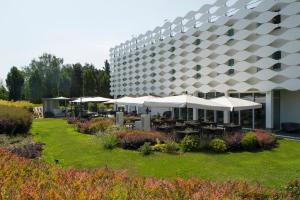 een gebouw met tafels en parasols in een tuin bij MO.OM Hotel in Olgiate Olona
