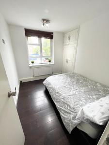 a small bedroom with a bed and a window at Large apt close to central LDN in London