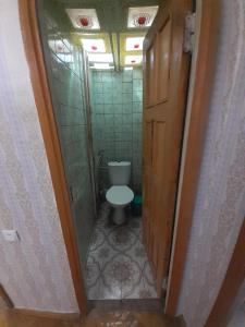 a small bathroom with a toilet and a door at LA's Apartment with closed parking in Alaverdi