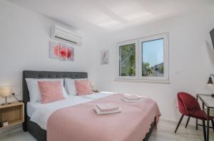 sypialnia z łóżkiem z różowymi poduszkami w obiekcie Modern Apartments Elle Malinska w mieście Vantačići