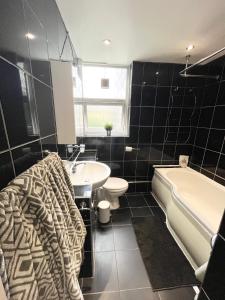 Large apt close to central LDN في لندن: حمام مع حوض وحوض استحمام ومرحاض