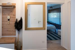 a door leading into a bedroom with a mirror at Apartman "Stay In" Osijek in Osijek