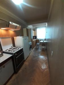a small kitchen with a stove and a refrigerator at LA's Apartment with closed parking in Alaverdi