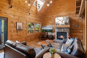 a living room with a couch and a fireplace at Mountain view 5 bdrm Gatlinburg Cabin near downtown Arts in Gatlinburg