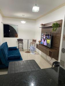 ein Wohnzimmer mit einem blauen Sofa und einem Flachbild-TV in der Unterkunft Flat com a melhor vista e localização da cidade! in São José da Coroa Grande