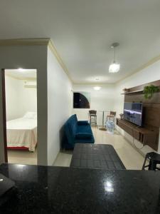 ein Wohnzimmer mit einem Bett und einer blauen Couch in der Unterkunft Flat com a melhor vista e localização da cidade! in São José da Coroa Grande
