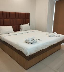 a bed with two flowers on top of it at Royal Pool View Apartment by Leela Homes in Old Goa +17 photos