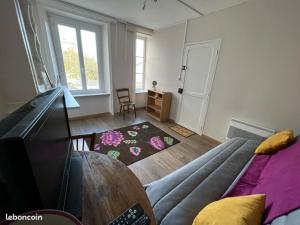 a living room with a bed and a tv in it at Le Tricorne in Saint-Vaast-la-Hougue