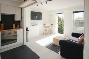 a kitchen and living room with a couch and a table at Magnificent Maida Vale 1bd apt for 3 in London