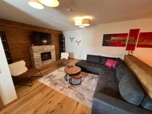 ein Wohnzimmer mit einem Sofa und einem Kamin in der Unterkunft Apartments Chalet Sonnentanz in Piesendorf