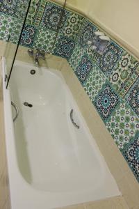 a bath tub in a bathroom with a tiled floor at Majorel Pearl Hotel-Riad-Restaurant Piscine&Spa in Marrakech